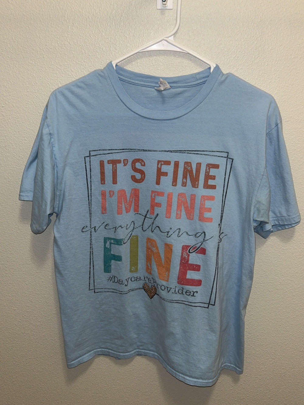 Port and Company Light Blue Short Sleeve Tee with Multicolor "It's Fine" Graphic
